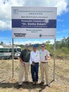 Three men at the Dr. Emilio Esbeih forest plantation sign